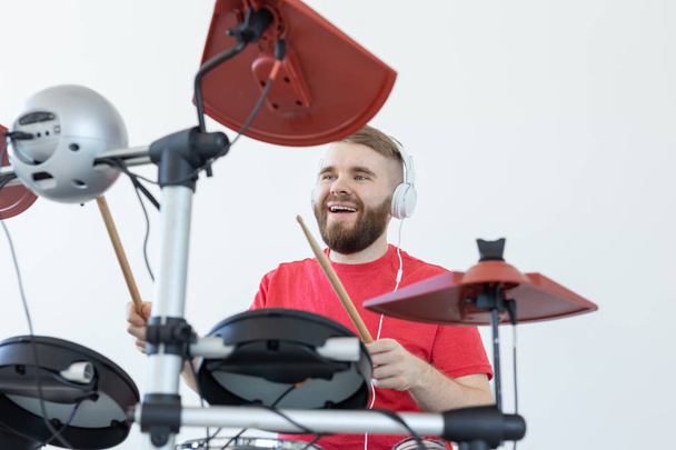 Drummer, hobby's en muziek concept-jonge man drummer in rood shirt het spelen van de elektronische drums - Foto, afbeelding