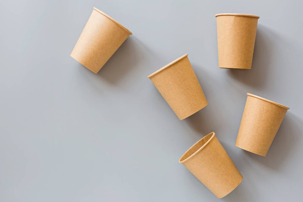 eco natural paper coffee cups flat lay on gray background. sustainable lifestyle concept. zero waste, plastic free items. stop plastic pollution. Top view, overhead, mockup, template - Foto, Imagem