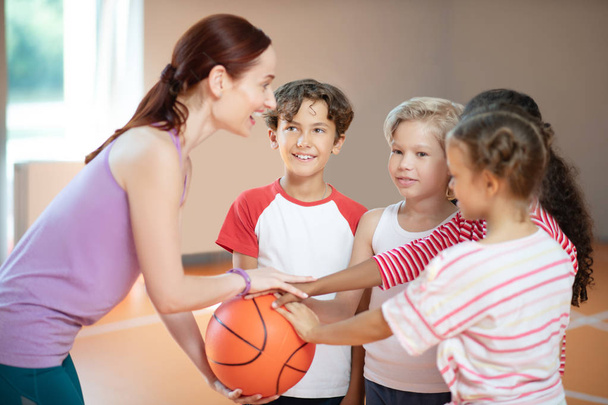 PE teacher and children smiling before starting basketball game - Foto, Imagem