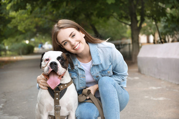 Young woman with cute dog in park - Фото, изображение