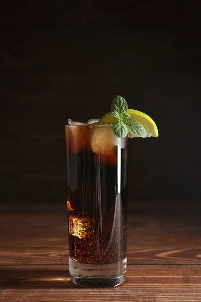 Bicchiere di cola fresca con ghiaccio sul tavolo di legno
 - Foto, immagini