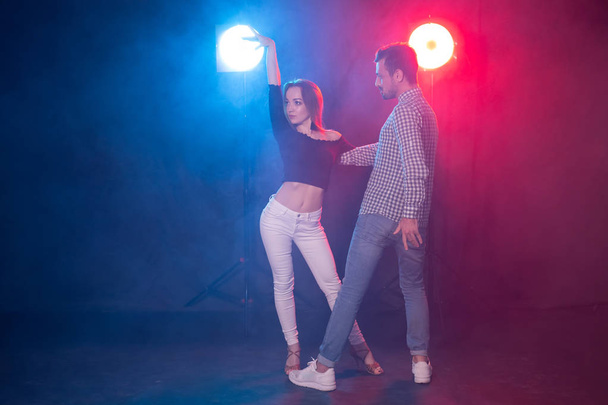 Danse sociale, kizomba, salsa et semba concept - jeune beau couple dansant la bachata ou la salsa dans le noir
 - Photo, image
