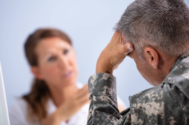 Mature Female Doctor Counseling Army Soldier Suffering From Stress In Clinic - Photo, Image
