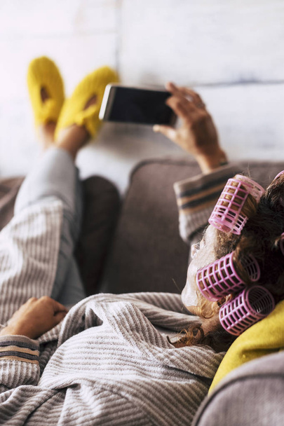 Relaxed young woman at home use smartphone lay down on sofa  - Zdjęcie, obraz