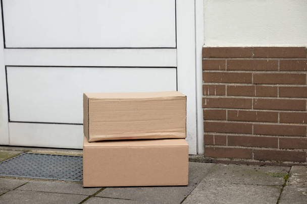 Stack Of Brown Cardboard Boxes Delivered At Doorstep - Foto, imagen