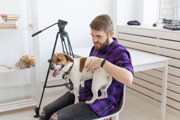 Animal, pet and people concept - Attractive cheerful man in plaid shirt holds favourite pet - Photo, Image