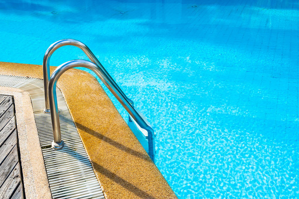 Beautiful outdoor swimming pool in hotel resort with stair - Fotó, kép
