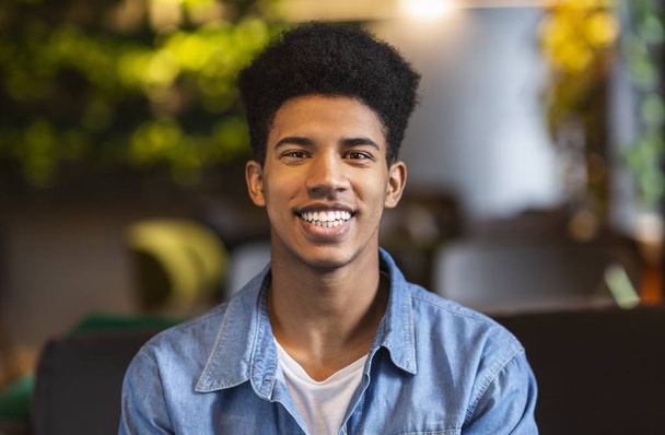 Portrait of cheerful afro teenager smiling at camera - Zdjęcie, obraz