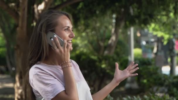 Beautiful girl joyfully talking on a cell phone - Séquence, vidéo
