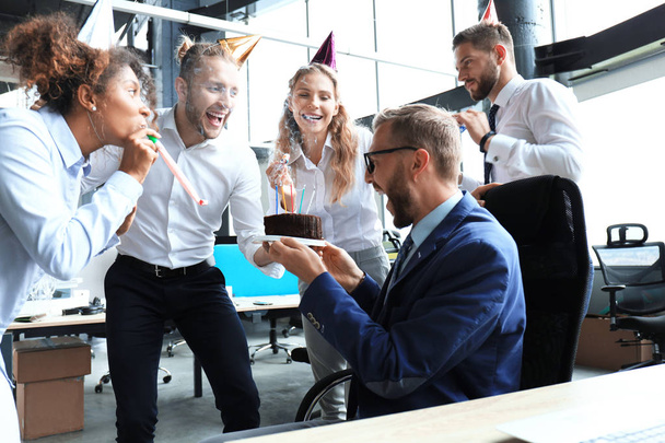 Business team celebrating a birthday of collegue in the modern office - 写真・画像