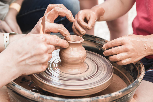 Una visione ravvicinata sul processo di produzione della ceramica sulla ruota del vasaio con i bambini. Artigianato in argilla con concetto bambini
. - Foto, immagini