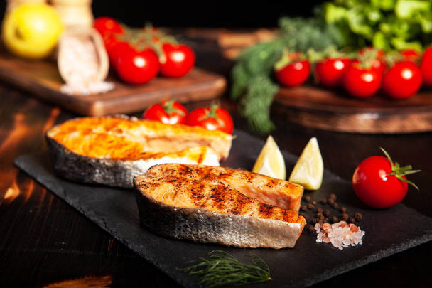 Grilled salmon rings placed on a stone platter - Photo, Image