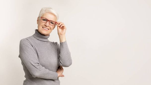 Belle femme d'affaires âgée dans des lunettes élégantes souriant à la caméra
 - Photo, image