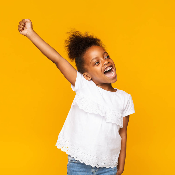 Cute african toddler girl shouting hooray on orange background - Photo, Image