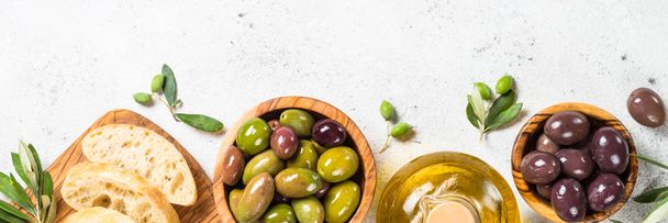 Aceitunas, ciabatta y aceite de oliva sobre fondo blanco. - Foto, imagen