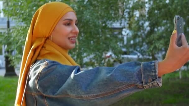Joven feliz hermosa mujer musulmana tomando selfie en la calle
 - Metraje, vídeo