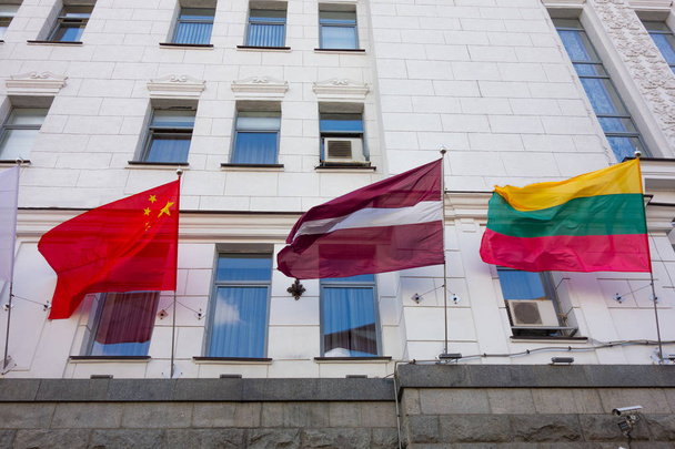 Falowane flagi narodowe na ścianie elewacji z oknami. Rząd lub  - Zdjęcie, obraz