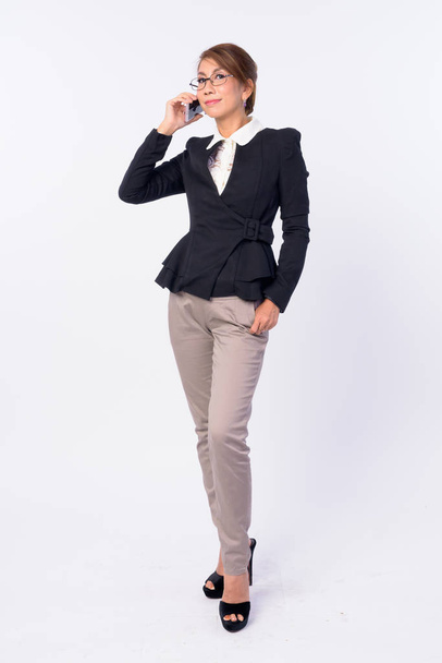 Full body shot of mature Asian businesswoman talking on the phone - Zdjęcie, obraz