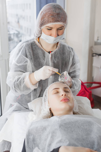 Master haciendo un procedimiento cosmético para su cliente. Tratamiento de la piel. mujer que realiza un procedimiento de atención facial. - Foto, Imagen