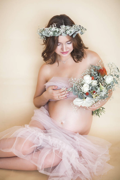 Красива вагітна жінка на нейтральному тлі. Очікуване крупним планом зображення. Майбутній портрет матері на пастельному тлі
. - Фото, зображення