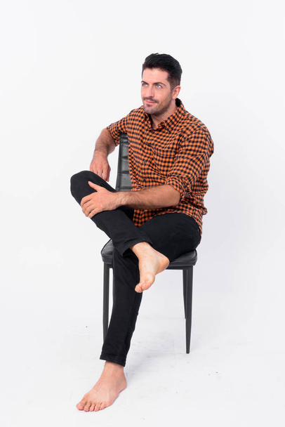 Full body shot of handsome bearded hipster man sitting on chair - Photo, Image