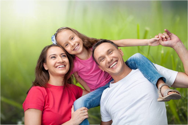 Happy smiling family with daughter on park background   - Фото, зображення