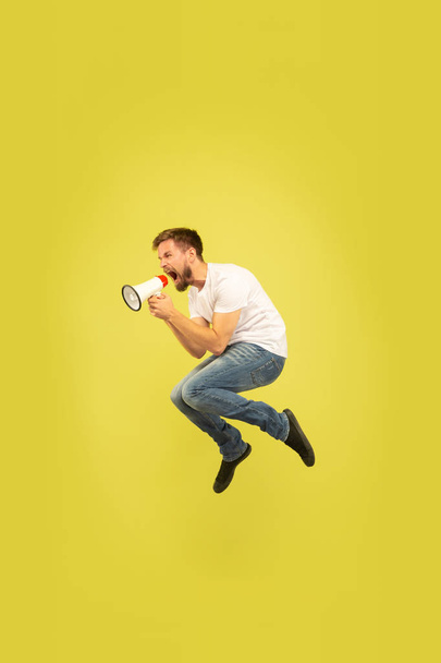 Портрет щасливого стрибаючого чоловіка на жовтому тлі
 - Фото, зображення