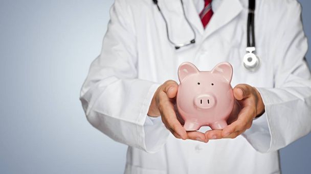 doctor holding piggy bank, Healthcare And Medicine. - Valokuva, kuva