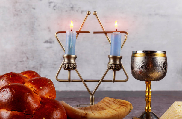 Shabbat with challah bread on a wooden table candles and cup of wine. - Photo, Image