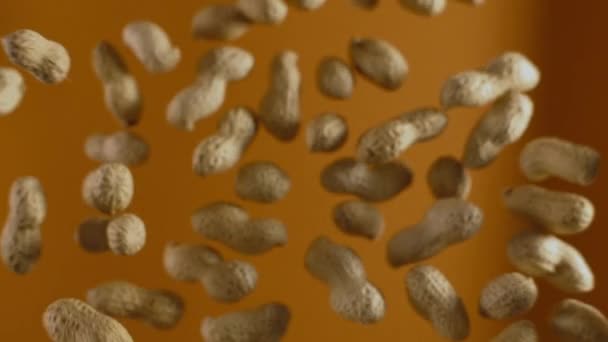 fallende Erdnüsse in Zeitlupe auf orangefarbenem Hintergrund, Slow Motion Food, 240fps full hd 10 bit - Filmmaterial, Video