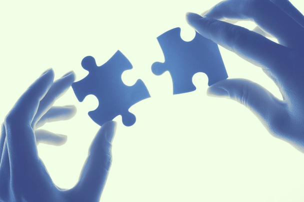Lavoro di squadra, cooperazione e partenariato, mani umane che tengono pezzi di puzzle
  - Foto, immagini