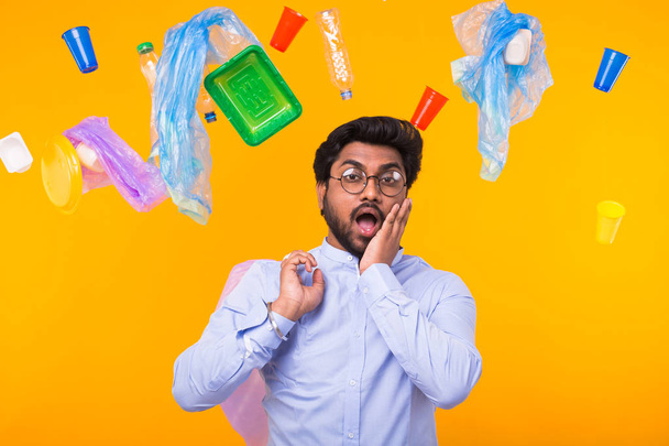 Día Mundial del Medio Ambiente, problema de reciclaje de plástico y concepto de desastre ambiental - conmocionado hombre indio sosteniendo bolsa de basura sobre fondo amarillo
 - Foto, imagen