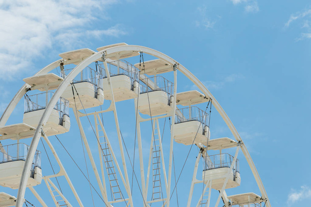 Ferris wheel on the blue cloudy sky.  Background concept of happy holidays time. - Foto, Imagen