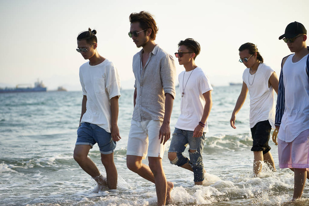 group of asian men walking on beach - Photo, image