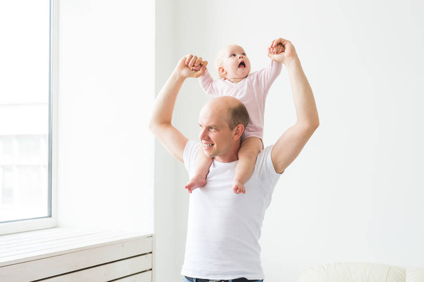 family, parenthood and fatherhood concept - happy father playing with little baby girl at home - Fotoğraf, Görsel