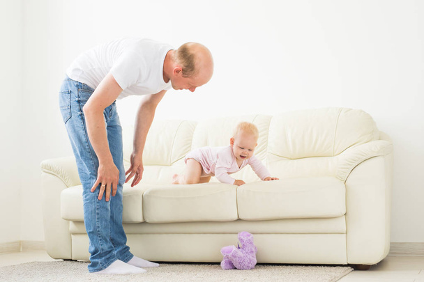 Концепция семьи, семьи и отцовства - счастливый отец играет с маленькой девочкой дома
 - Фото, изображение