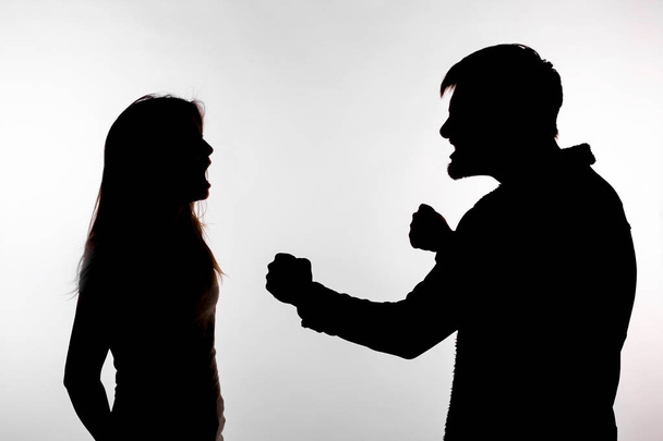 Conceito de agressão e abuso homem e mulher expressando violência doméstica em silhueta estúdio isolado em fundo branco
. - Foto, Imagem