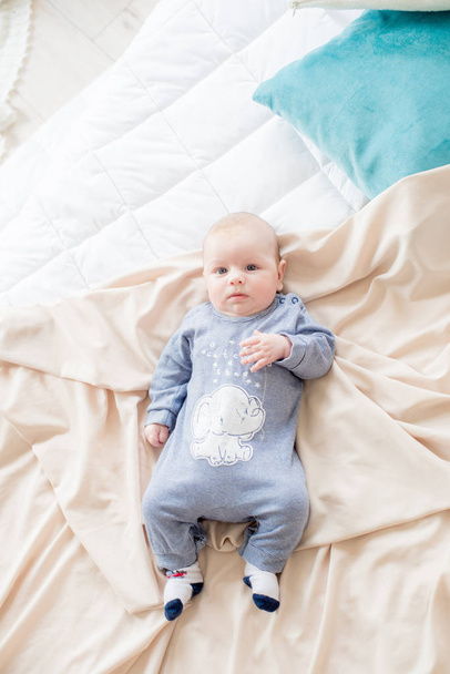 Little cute toddler is lying at home on the bed. Happy childhood - 写真・画像
