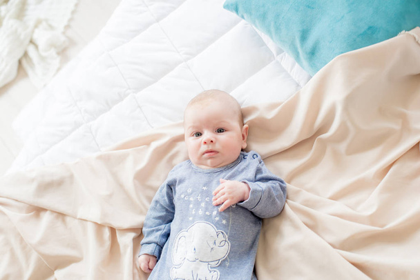 Little cute toddler is lying at home on the bed. Happy childhood - Fotó, kép