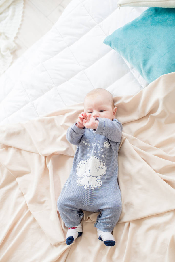 Little cute toddler is lying at home on the bed. Happy childhood - Foto, afbeelding