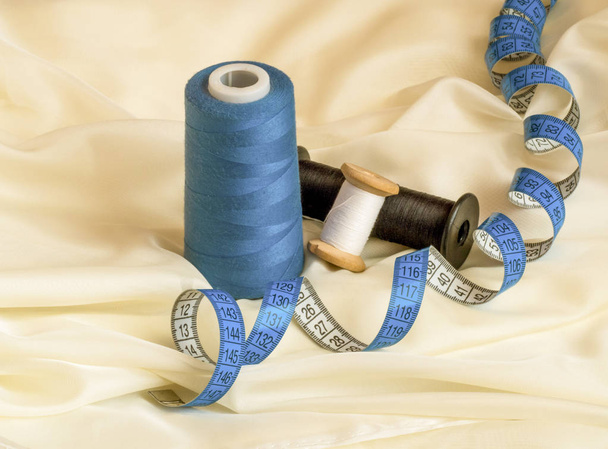 Three threads of different colors and blue twisted tape measure  - Photo, Image