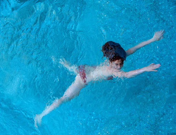 redhair vrouw zwemmen onder water - Foto, afbeelding