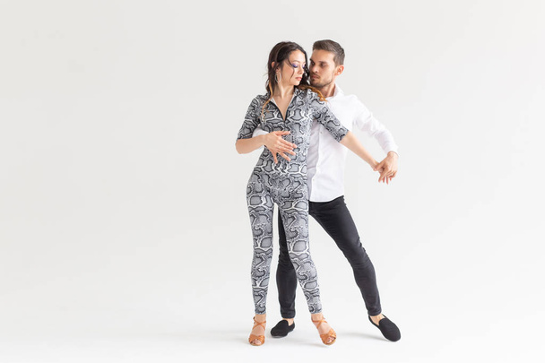 Danse sociale, bachata, kizomba, tango, salsa, concept de personnes - Jeune couple dansant sur fond blanc avec espace de copie
 - Photo, image