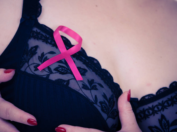 Pecho de mujer en sujetador, cinta de cáncer rosa
 - Foto, imagen