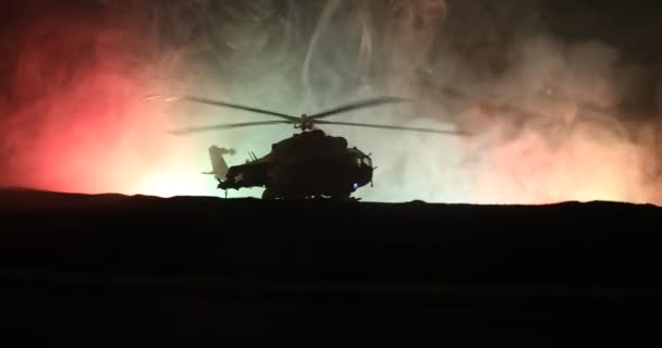 Silhouette d'hélicoptère militaire prêt à décoller de la zone de conflit. Images de nuit décorées avec hélicoptère commençant dans le désert avec rétroéclairage tonique brumeux. Concentration sélective
. - Séquence, vidéo