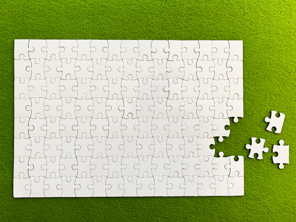 Felülnézet, fehér puzzle zöld háttérrel - Fotó, kép