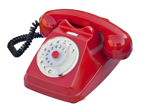 Старый красный пластиковый аналоговый телефон на белом фоне для удобства
  - Фото, изображение