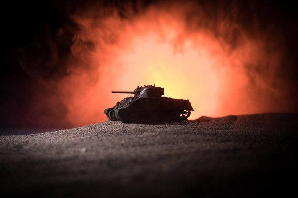戦争の概念。●戦争霧空を背景に戦闘シーンを戦うミリタリーシルエット、夜の曇りスカイライン下の装甲車のシルエット。攻撃シーン。戦車の戦い. - 写真・画像