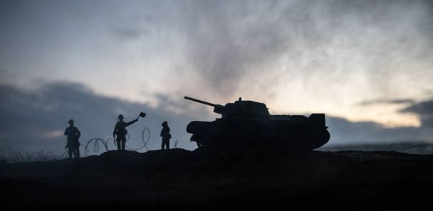 Πολεμική ιδέα. Στρατιωτικές σιλουέτες αγωνίζονται σκηνή στον πόλεμο ομίχλη ουρανό φόντο, παγκόσμιος πόλεμος Γερμανικά άρματα φιγούρες κάτω από συννεφιασμένο ορίζοντα τη νύχτα. Επίθεση σκηνή. - Φωτογραφία, εικόνα