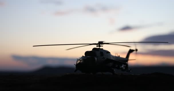Silhueta de helicóptero militar pronta para voar da zona de conflito. Filmagem noturna decorada com helicóptero começando no deserto com nevoeiro tonificado retroiluminado. Foco seletivo
. - Filmagem, Vídeo